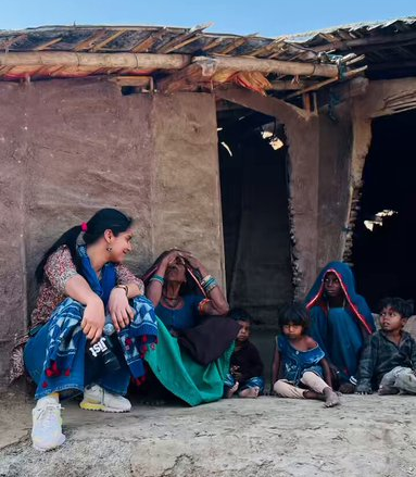 पत्रकार मेधा यादव, ग्रामीण परिवार के साथ संवाद करती हुईं